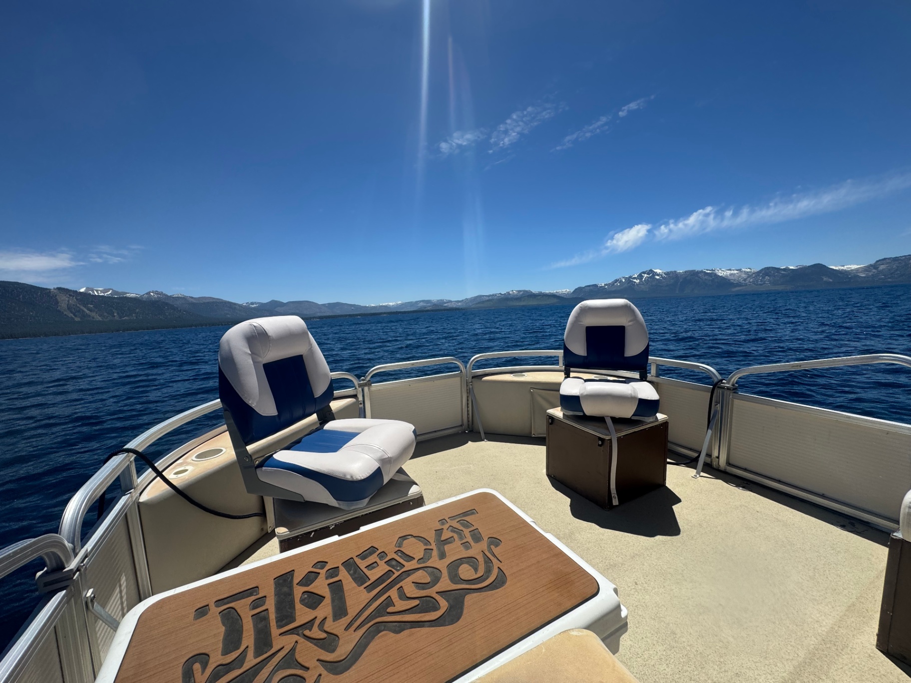 Tiki Boat carved table on the foredeck with Tahoe behind