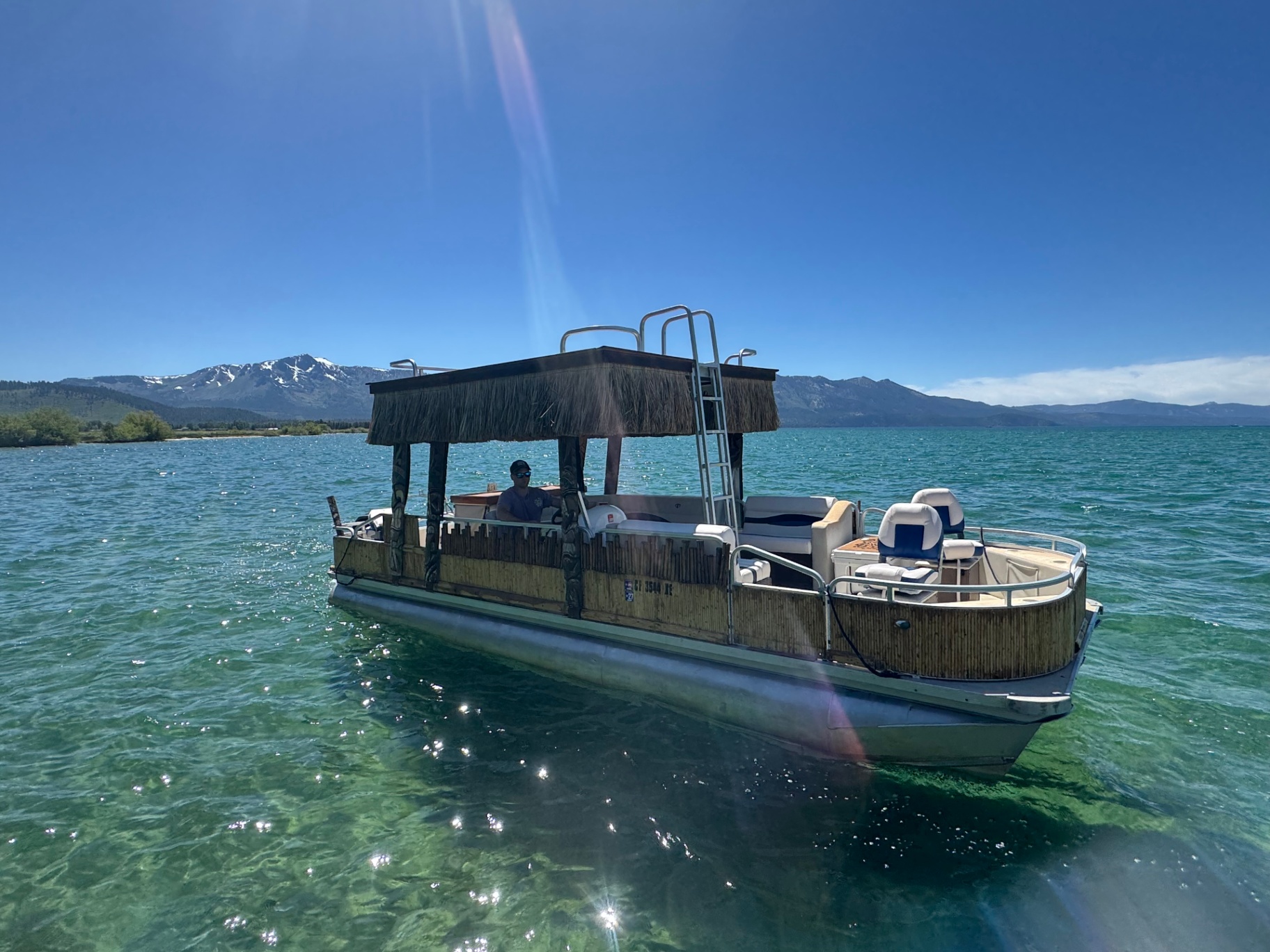 Tahoe Tiki Cruz boat on emerald Tahoe water at midday